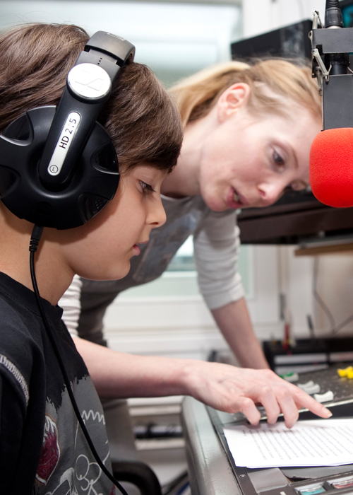 Kind und Moderatorin hinter dem Mikrofon im Radio | Kindergeburtstag Radio Feierwerk 