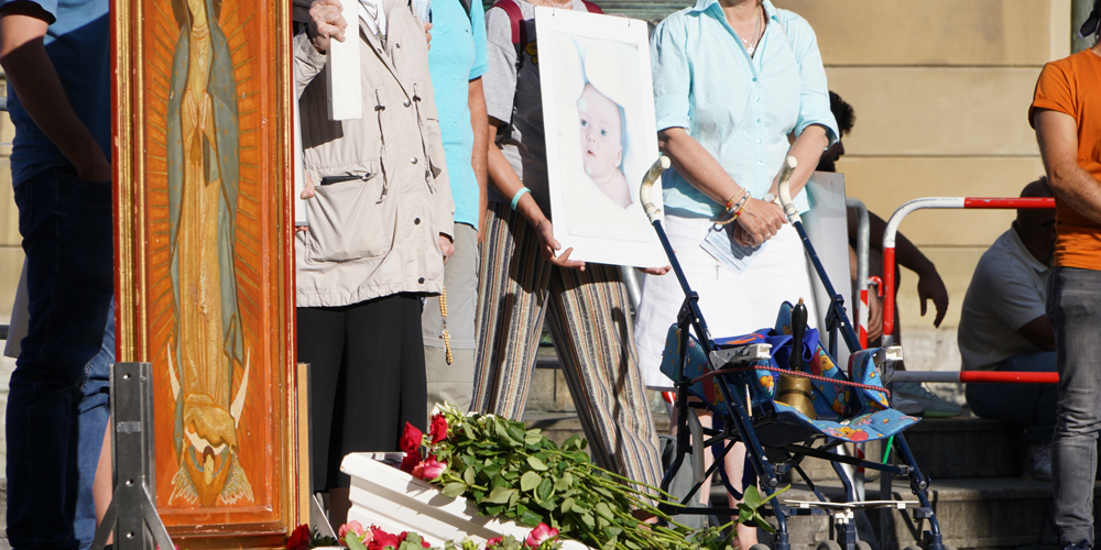 Auf dem Odeonsplatz legen die Teilnehmenden der Kundgebung Rosen in einen Kindersarg. 