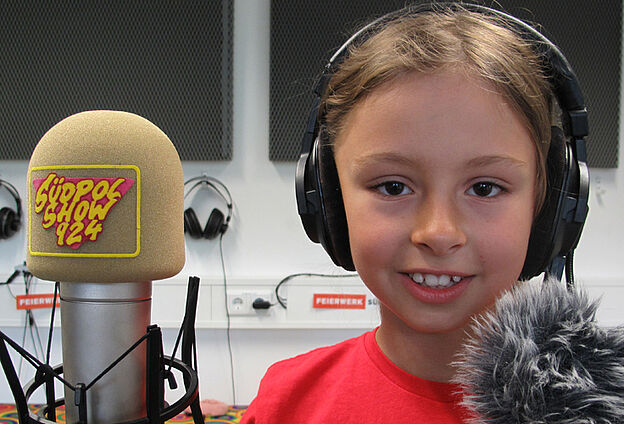 Foto Radio-Intensiv-Workshop mit der Feierwerk Südpolstation. Zu sehen ist ein Mädchen neben dem Südpolshow Mikro.