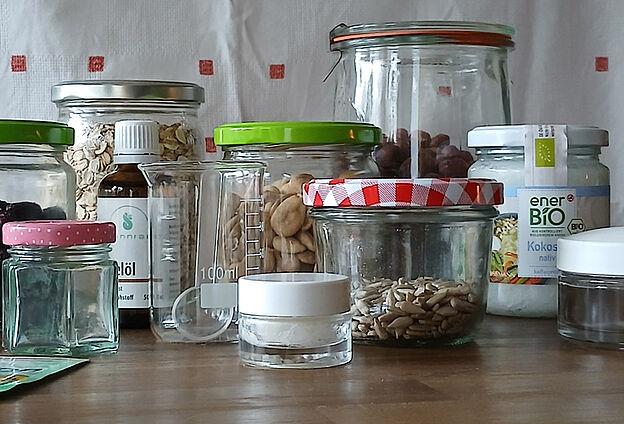Foto Wellness-Day mit Feierwerk Boom. Zu sehen sind unterschiedliche Glasgefäße, gefüllt mit Körnern, Nüssen und Trockenfrüchten.